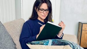 A woman reading or journaling in a peaceful setting